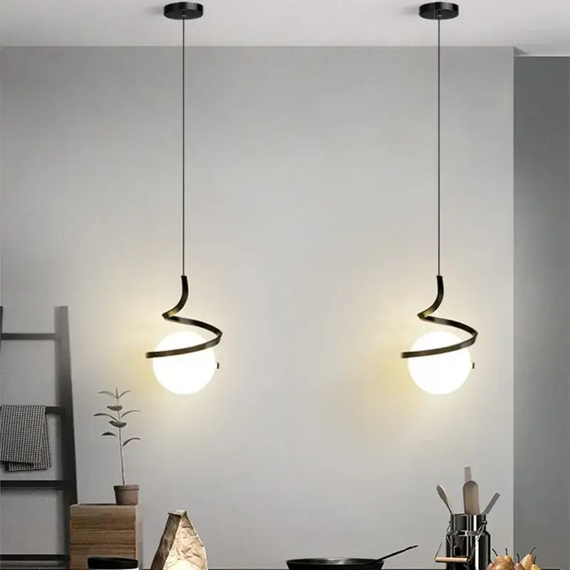 Two sleek black spiral cord pendant lights with frosted glass globes ideal for cord pendant installation in dining rooms