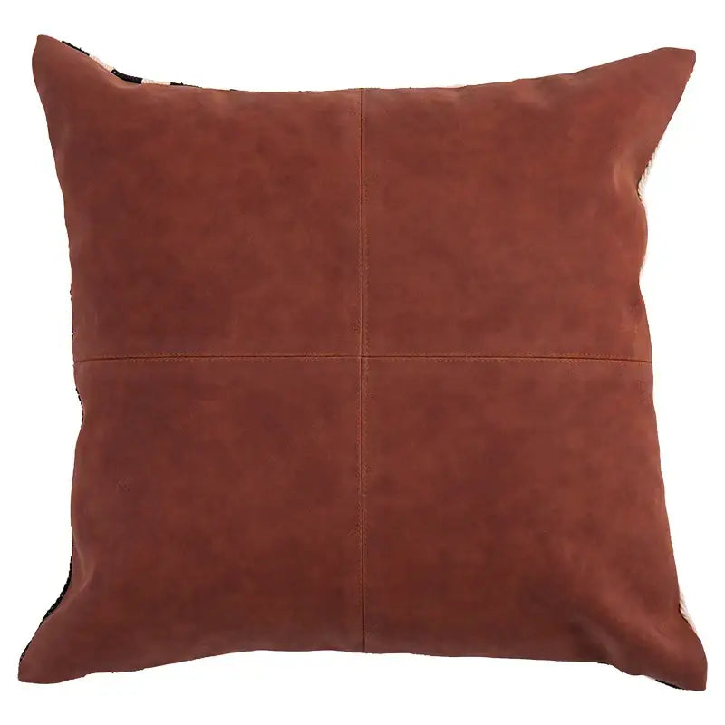 A rust-colored suede pillow cover with visible quadrant stitching complementing decorbites black stripe faux leather design