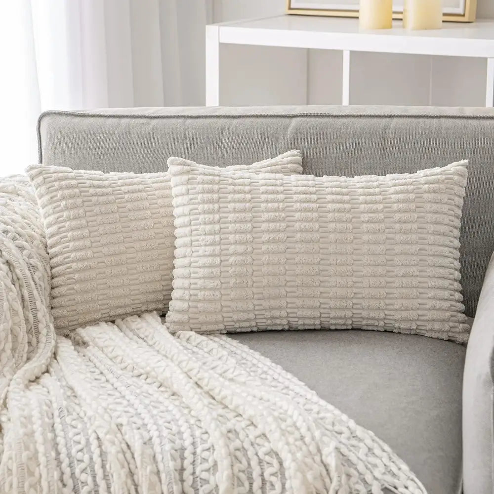 Cream-colored rectangular throw pillows with textured ribbed fabric complement decorbites black striped corduroy throw cover
