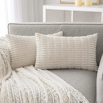 Cream-colored rectangular throw pillows with textured ribbed fabric complement decorbites black striped corduroy throw cover