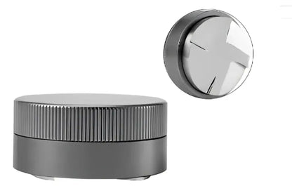 Silver metallic herb grinder with ribbed cylindrical body and x-shaped top cap paired with decorbites espresso tamper