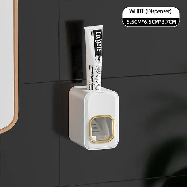 White toothpaste dispenser with gold trim holding colgate tube inside black translucent decorbites inverted toothbrush holder