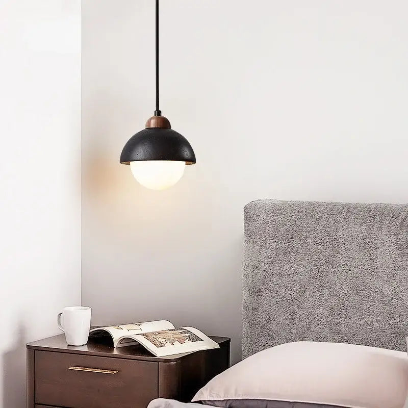 Black travertine pendant light with matte black dome shade brass accent emitting warm light decorbites glass ball