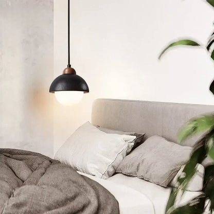 Black travertine pendant light with matte finish and copper hardware hanging above bed decorbites glass ball lamp