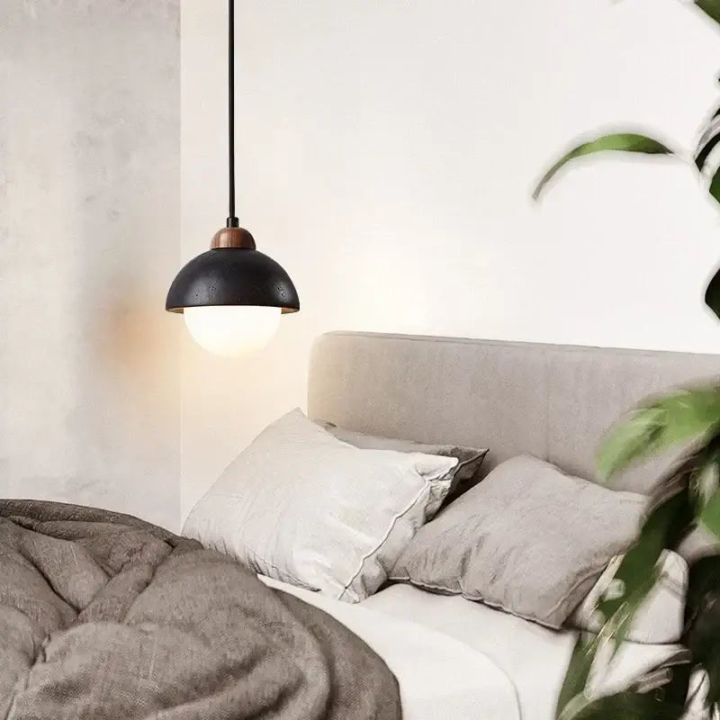Black travertine pendant light with matte finish and copper hardware hanging above bed decorbites glass ball lamp