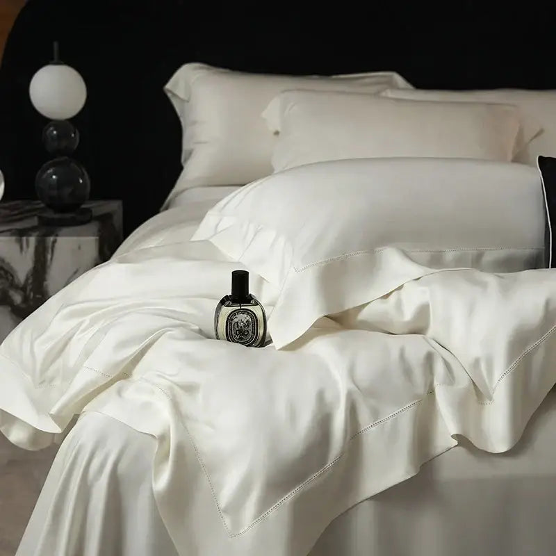 Cream-colored silk bedding set with elegant satin finish and subtle stitching made from lyocell eucalyptus fiber for luxury bedroom use