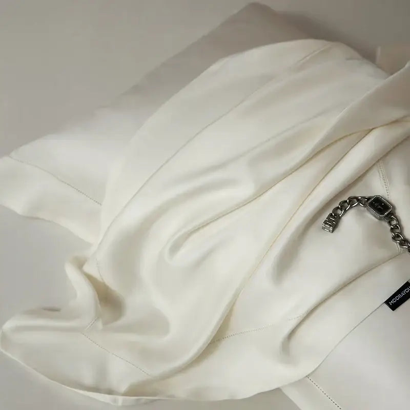 A soft off-white silk blouse with delicate stitching paired with a black velvet lyocell eucalyptus fiber bedding set