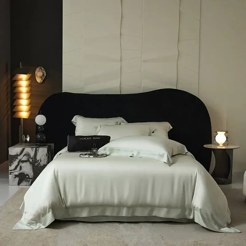 Black upholstered bed with curved headboard and white satin lyocell eucalyptus fiber bedding set for luxury bedroom use