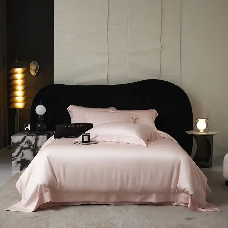 A plush blush-pink satin duvet bedding set with ruffled edges made of lyocell eucalyptus fiber for luxury softness