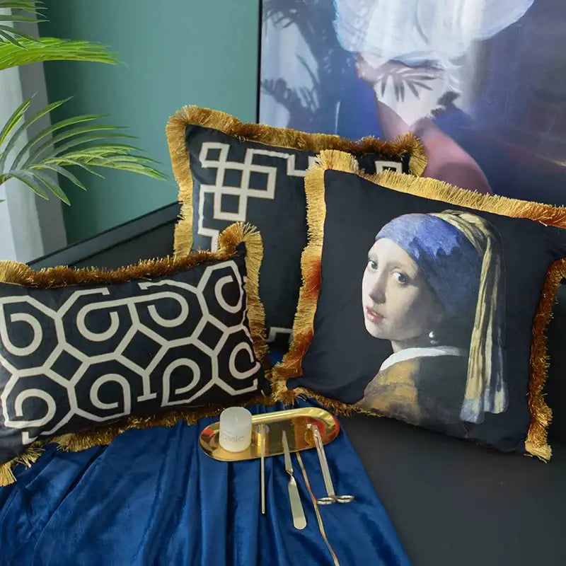 Black and white geometric fringed lumbar pillow cover with black throw pillows featuring gold fringe and vermeer design