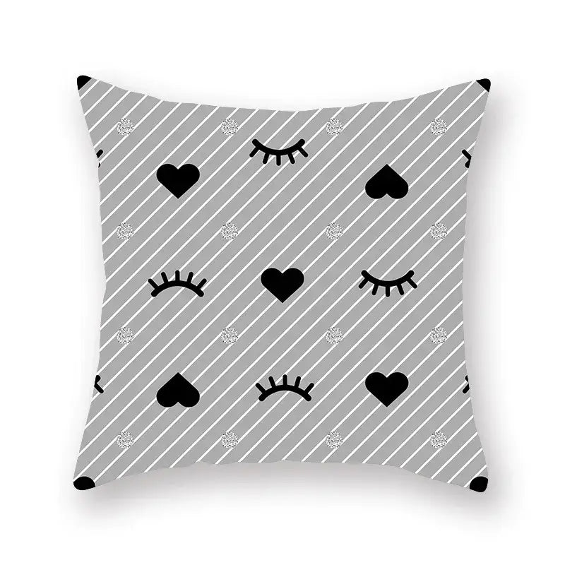 Gray throw pillow with black hearts closed eyes and silver glitter dots on a geometric star stripe print pattern