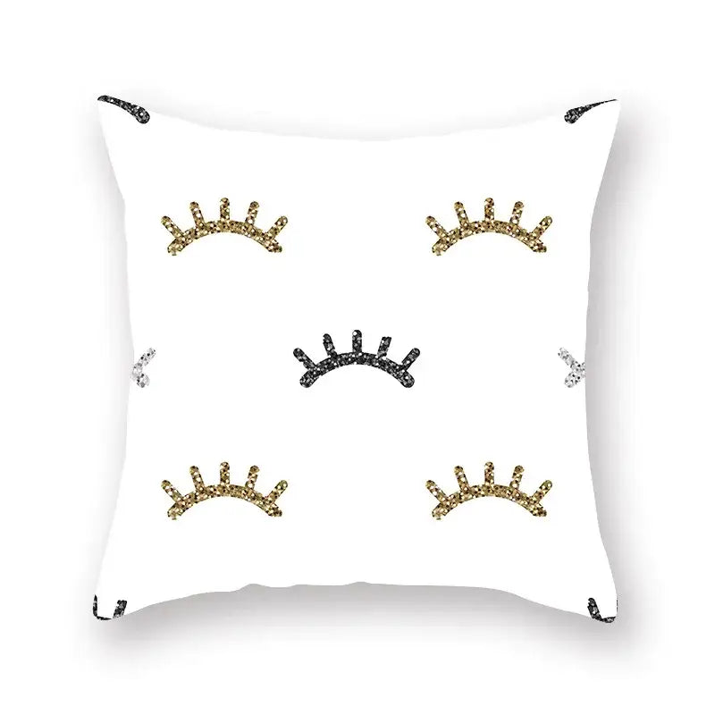 White throw pillow with glittery gold black and silver eyelash designs featuring geometric star stripe print decor