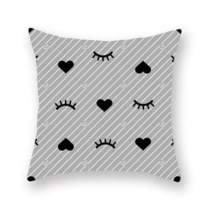 Gray throw pillow with black hearts and closed eyes on a geometric star stripe pattern with silver glitter dots for décor