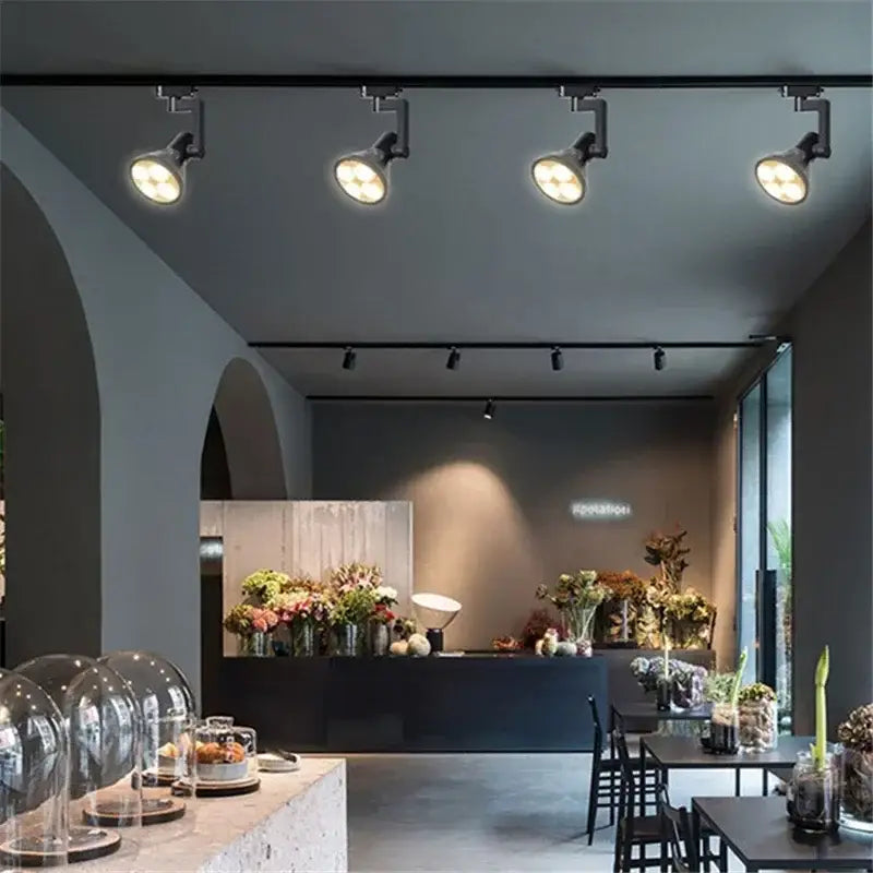 Black and white metallic decorbites cob ceiling spotlight with 4 adjustable led lights illuminating a modern floral shop interior