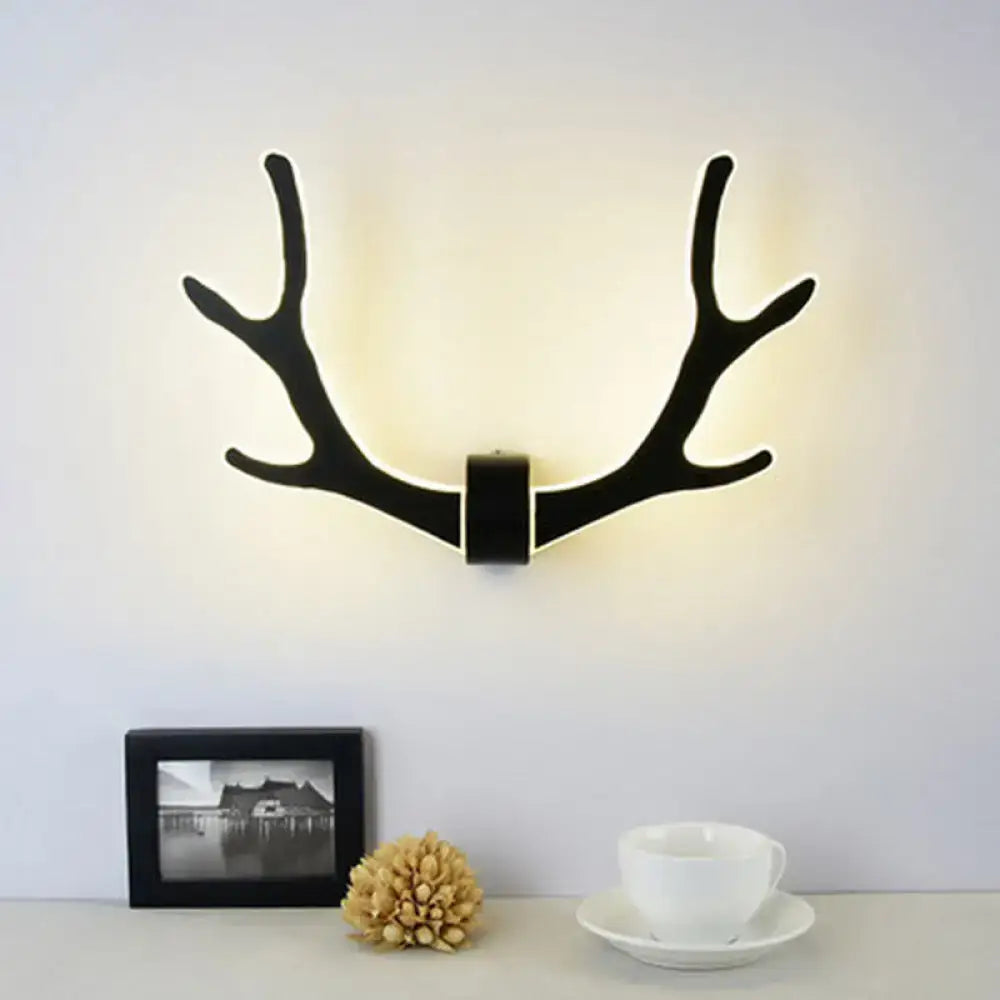 Black wooden antler wall lamp with warm glowing led light ideal for corridor use as an antler wall sconce