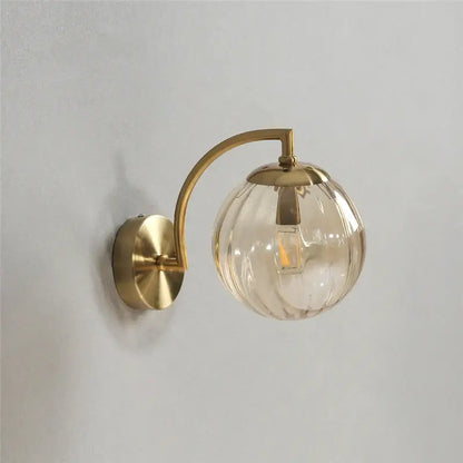 Brass-finished wall lamp with clear ribbed glass colored glass ball and led bulb for bedroom lighting decorbites