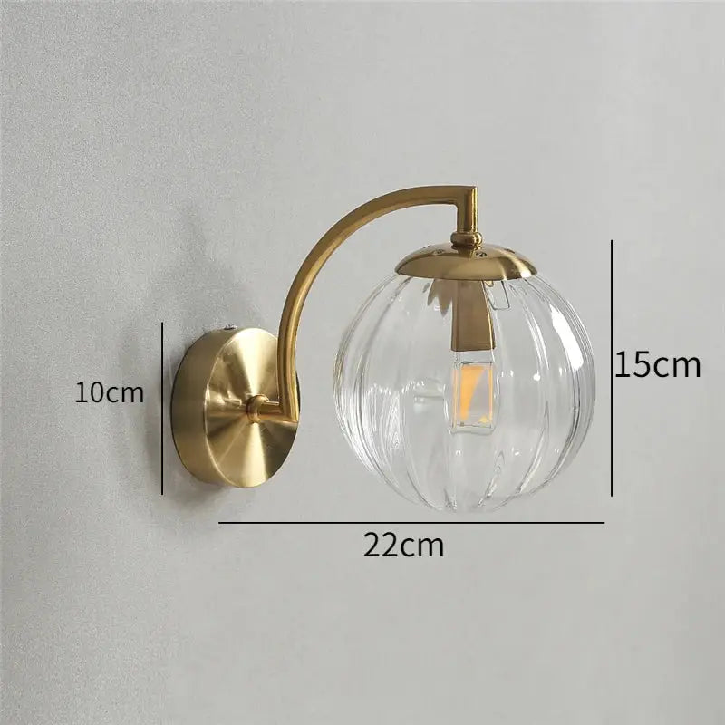 Brass-finished wall lamp with blue and brass colored glass ball and clear ribbed globe for bedroom lighting decorbites colored glass
