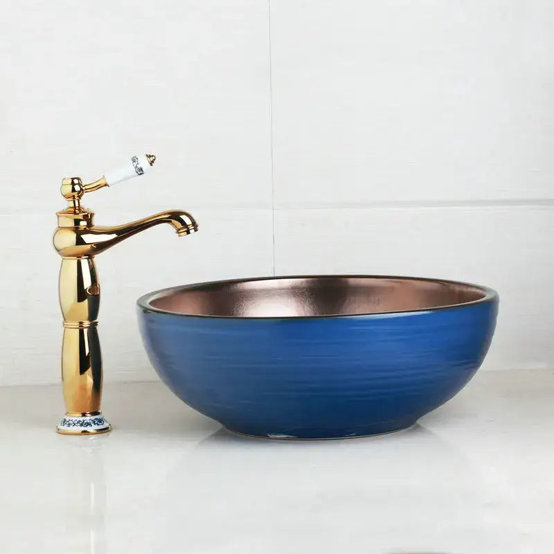 Blue and copper hand painted ceramic vessel sink set with copper interior and gold-toned bathroom faucet