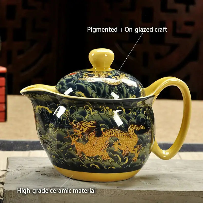 A glossy black ceramic decorbites dragon teapot with gold dragon and wave motifs in a tea set for dining room use