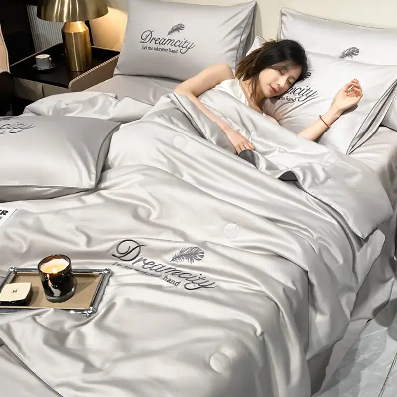 Silver satin quilt set with dreamcity embroidery and feather motifs made of embroidered ice silk summer fabric