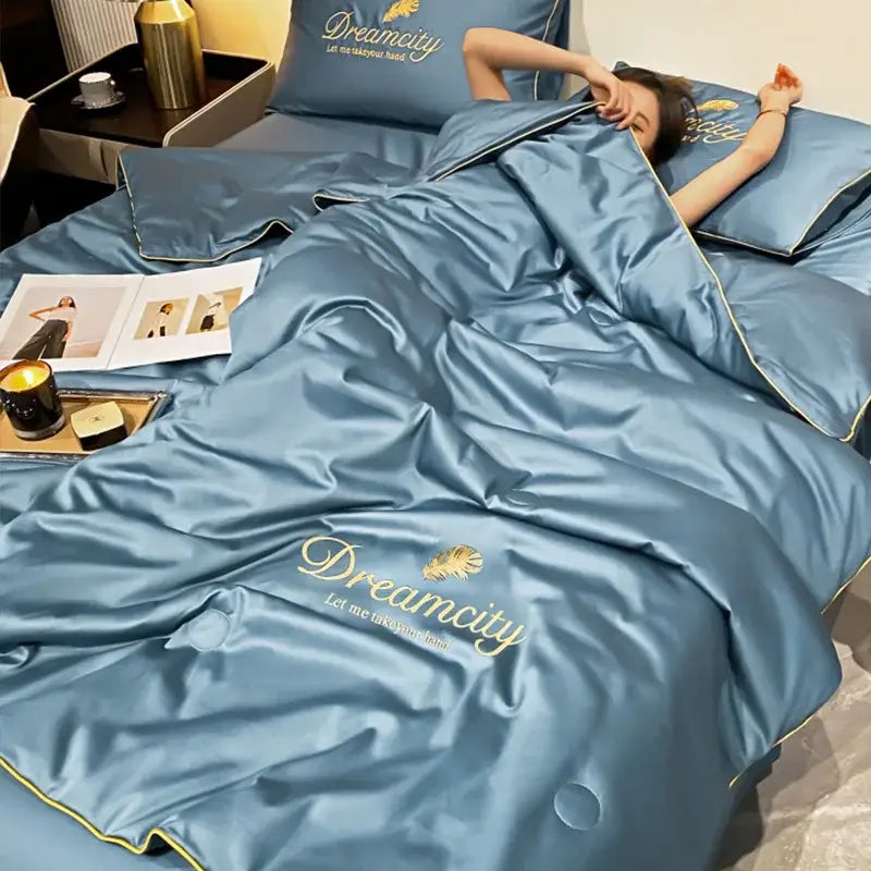 Blue and gold embroidered ice silk summer quilt set with dreamcity brand name and feather design on satin duvet