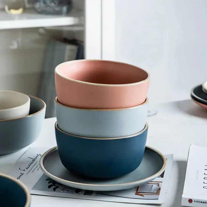 Stacked decorbites ceramic morandi bowls in soft pink muted blue and deep navy with subtle gold trimmed rims for dining room use