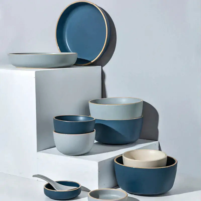 Blue and gray ceramic morandi bowl dining room gold trimmed dinnerware displayed on white blocks by decorbites ceramic morandi
