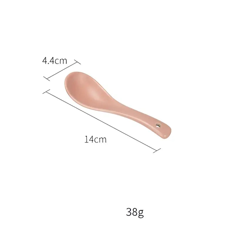 A sleek matte pink ceramic spoon with a hole in the handle complements the blue and gray decorbites ceramic morandi bowl dinnerware