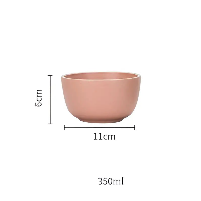 A matte pink decorbites ceramic morandi bowl with smooth round shape and gold trimmed dining room design