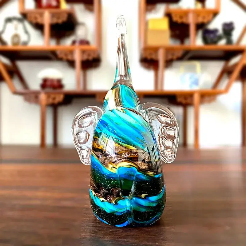 A vibrant blue and green crystal glass elephant sculpture with gold flecks for elegant living room decor