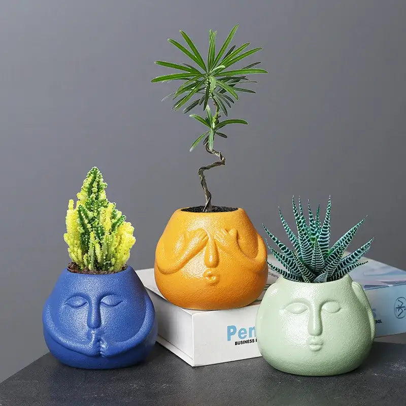 Three colorful decorbites ceramic abstract human face planters in blue orange and mint green for living room decor