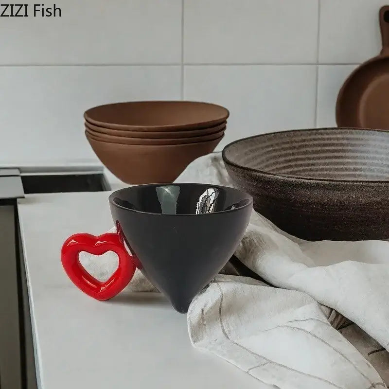 A glossy black ceramic bowl with a vibrant red decorbites heart shape handle for fruit juice and kitchen use