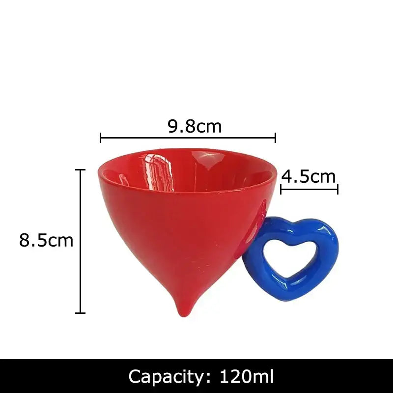 A vibrant red glossy heart shape ceramic cup with a blue handle from the decorbites fruit juice mug set