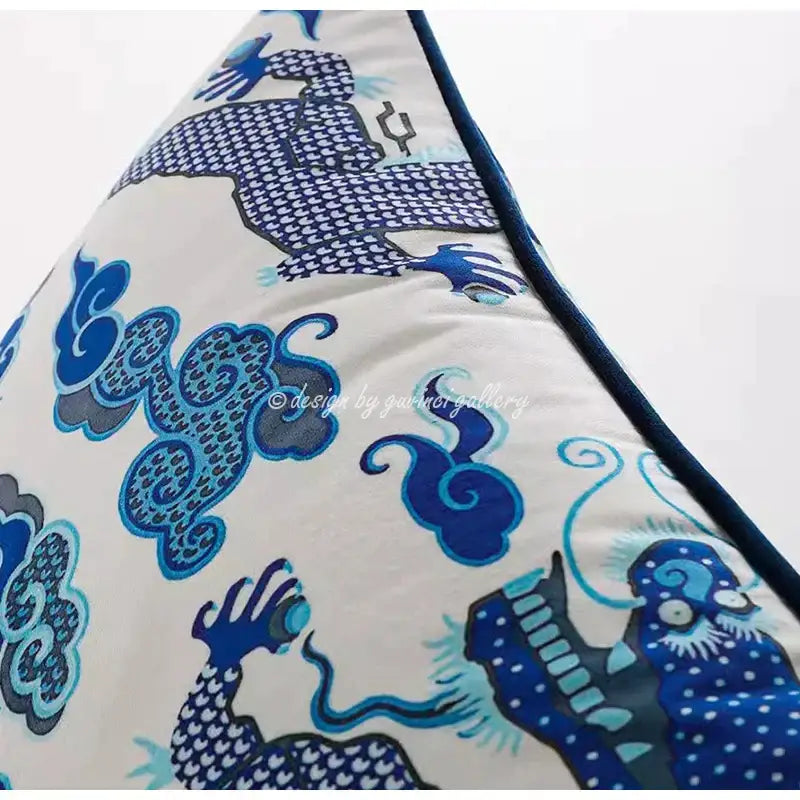 Cream triangular throw pillow case with blue and teal dragon motif and tassels for living room decor