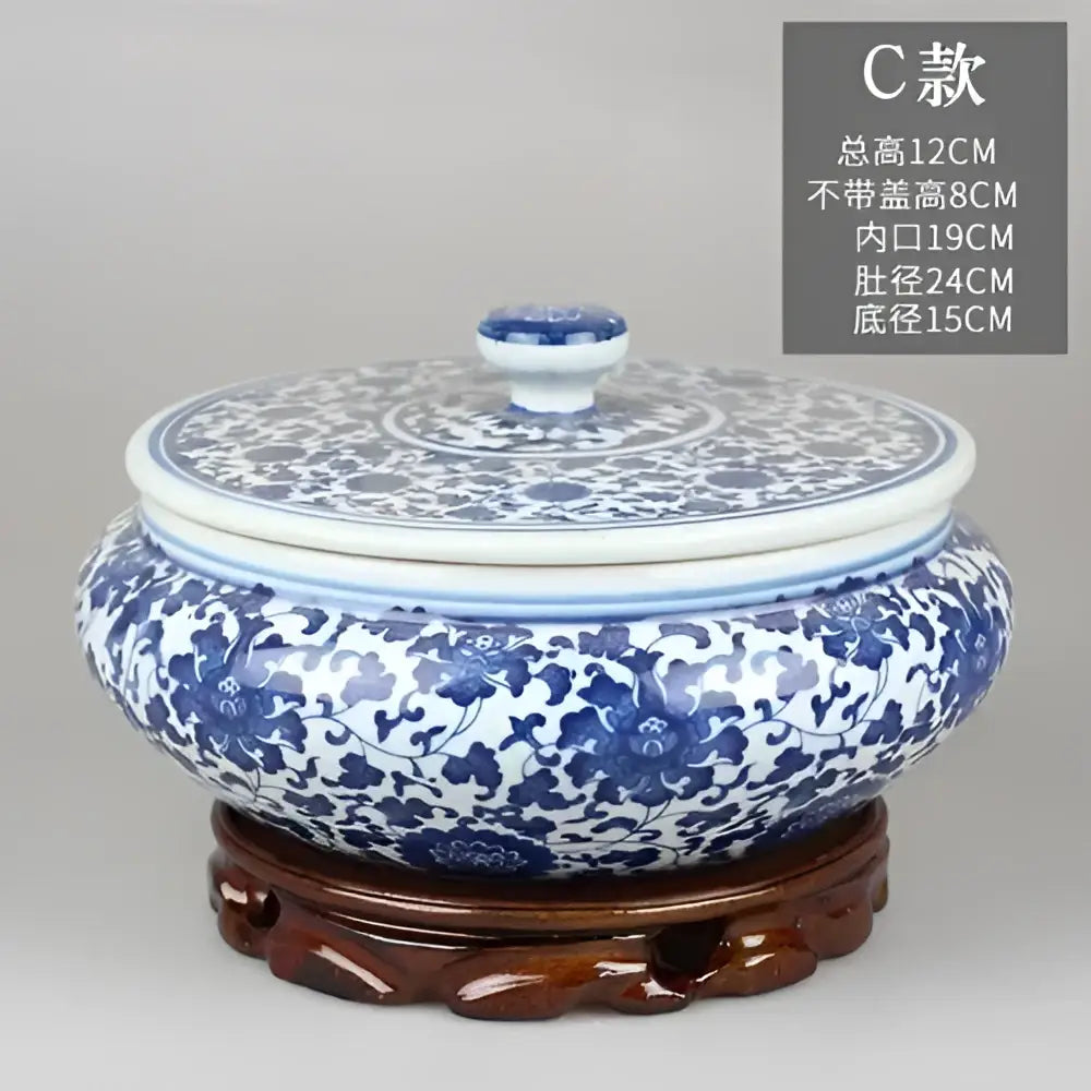 Blue and white floral ceramic tea caddy jar with intricate patterns resting on carved wooden stand for living room decor