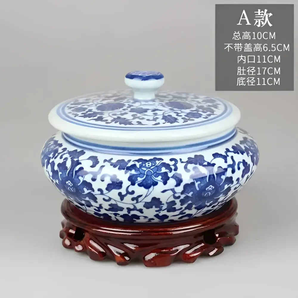 Blue and white floral ceramic tea caddy jar with intricate patterns resting on a carved wooden stand for living room decor