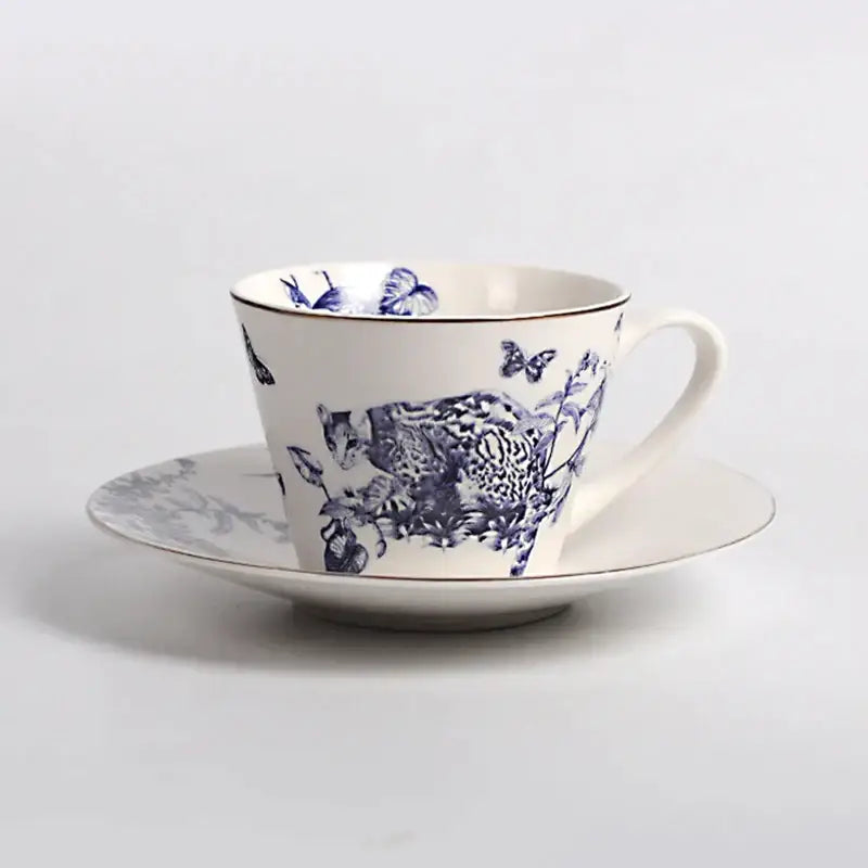 White porcelain teacup and saucer with blue hand-painted cat and butterflies for decorbites kitchenware dining experience