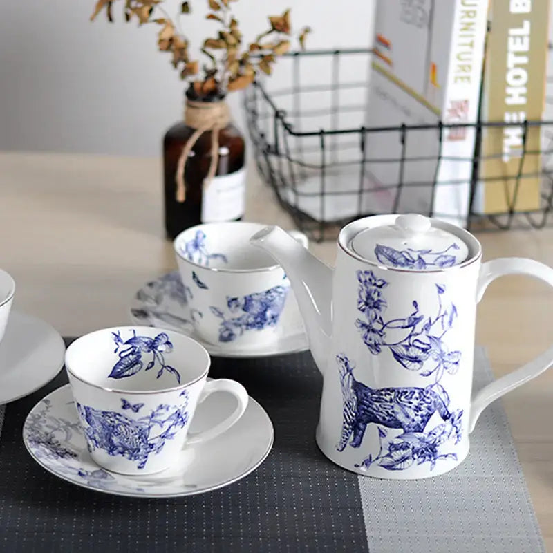White porcelain teapot with blue floral and animal motifs and gold rimmed lid from decorbites kitchenware dining experience set