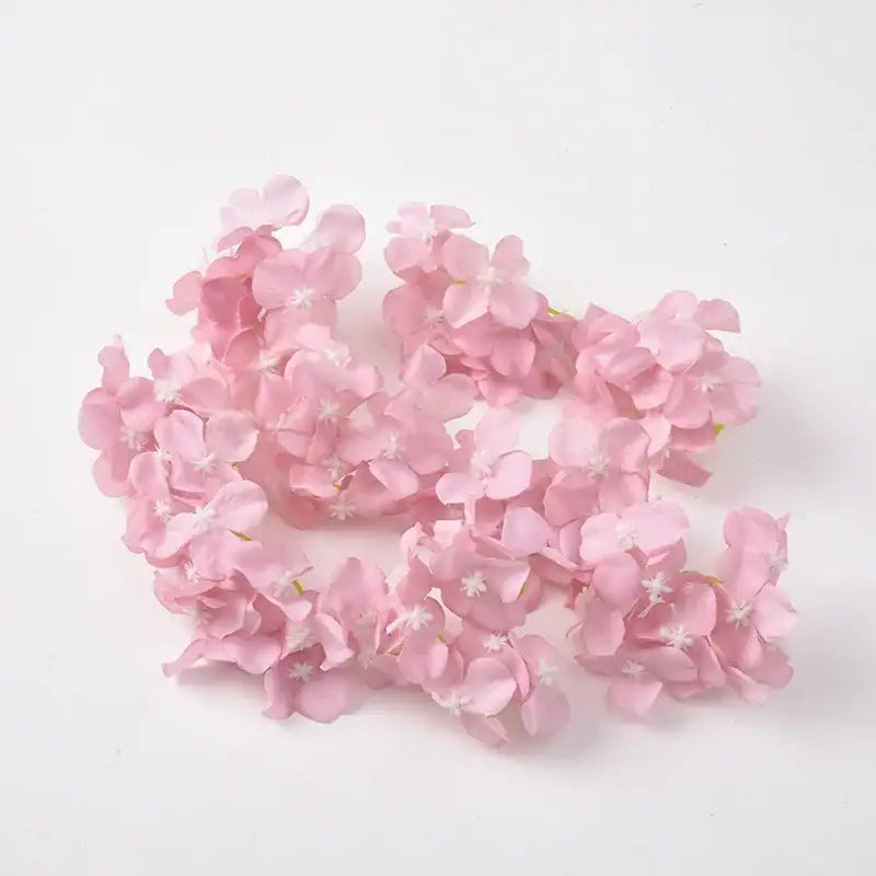 A delicate cluster of artificial pink cherry blossoms with white centers complementing decorbites hydrangea flowers wedding decor