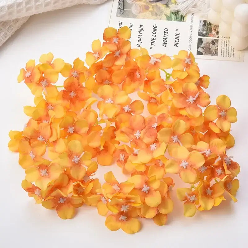 A cluster of artificial orange and yellow hydrangea flowers with white centers for decorbites hydrangea wedding decor