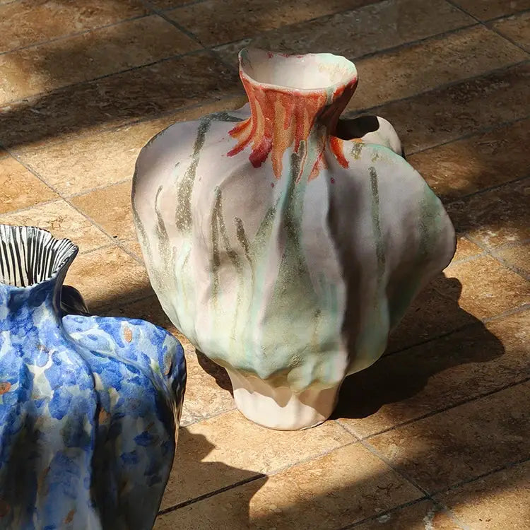 A handcrafted irregular porcelain tulip vase with a bulbous form and mottled pink green and brown glaze for decorbites decor