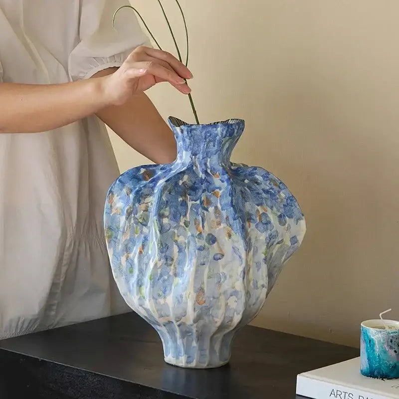 A textured blue and white irregular porcelain tulip vase with floral pattern and ribbed design for living room decorbites decor