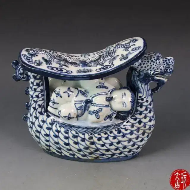 Blue and white porcelain dragon boat statue with detailed scales and painted dragon and children motifs for bedroom decor