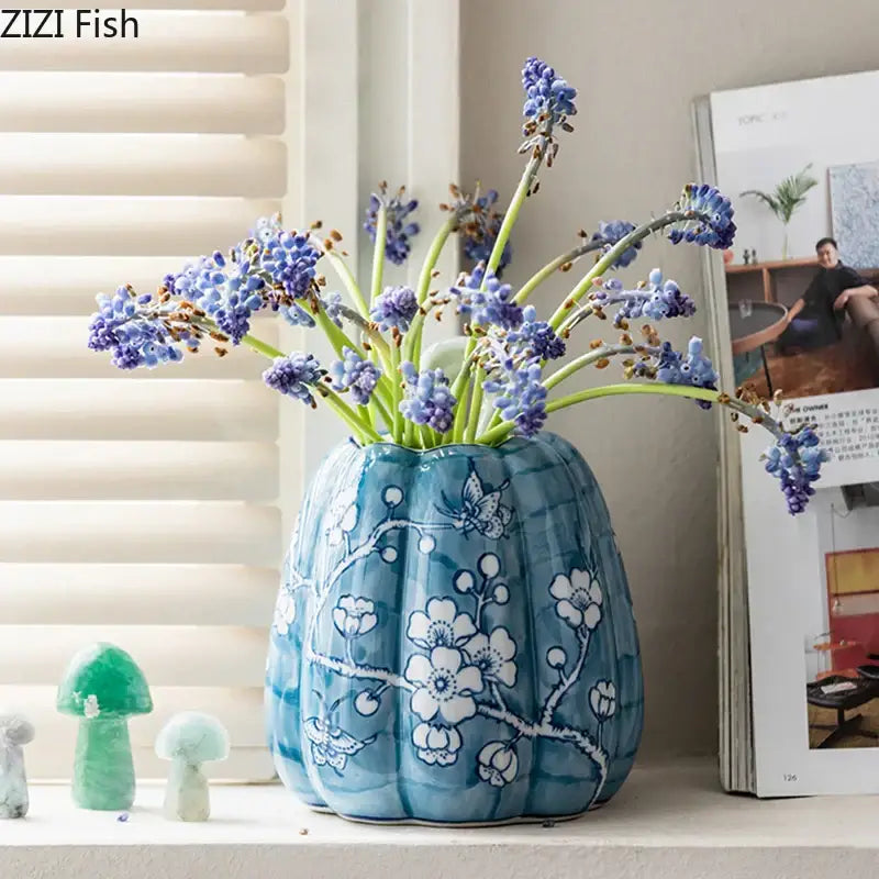 A blue white porcelain pumpkin vase with white floral and butterfly patterns ideal for living room decor