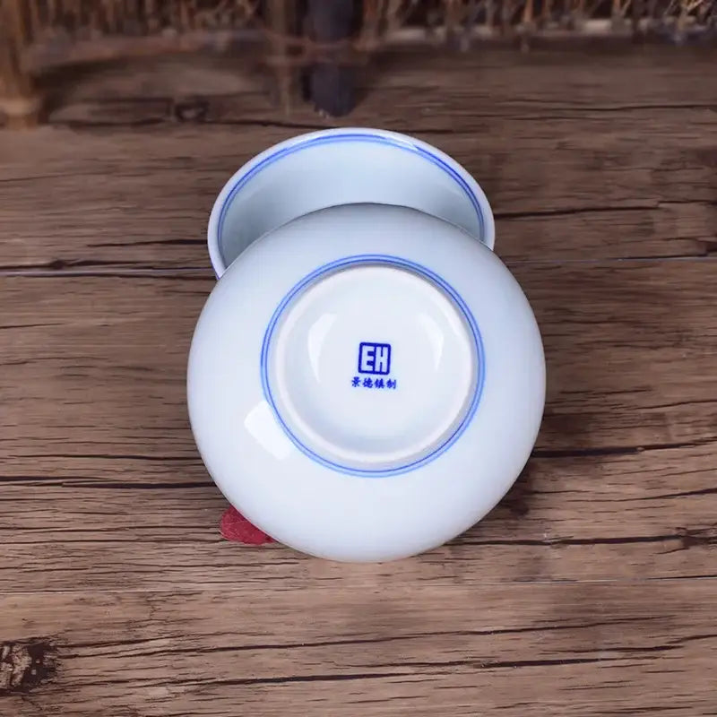 White porcelain rice bowl with blue rim and logo showcasing traditional chinese porcelain craftsmanship