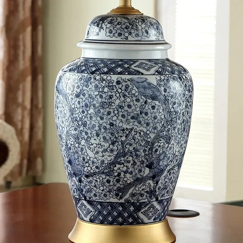 Blue and white porcelain table lamp with intricate floral and bird designs and gold accents by decorbites for living room decor