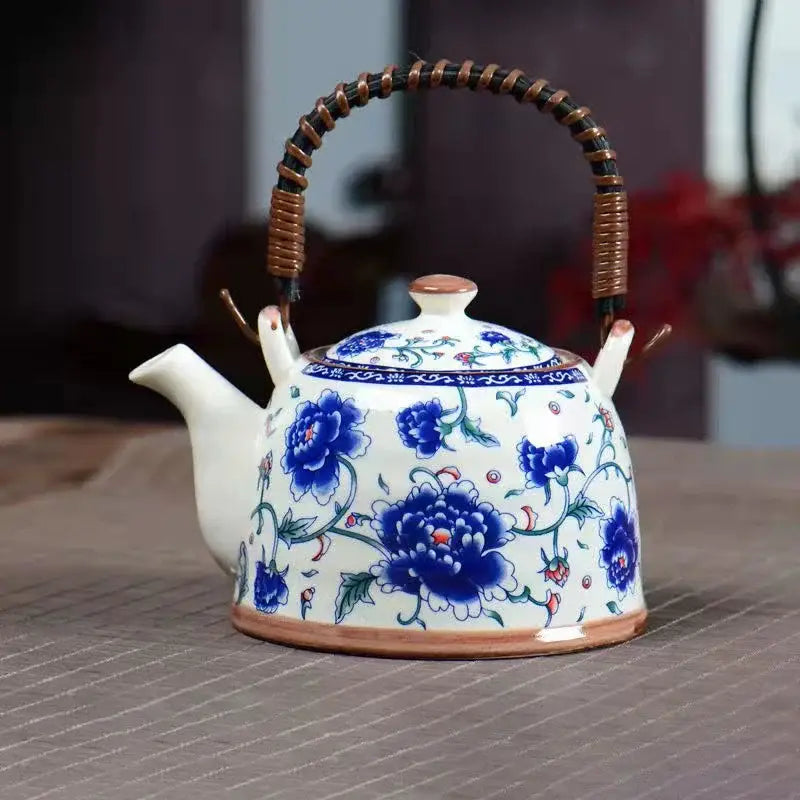 White porcelain teapot with intricate blue floral patterns and woven handle from decorbites blue dining room set