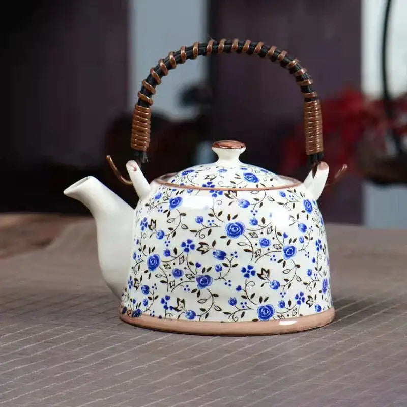 White porcelain teapot with delicate blue floral pattern and brown woven handle for dining room decorbites blue set
