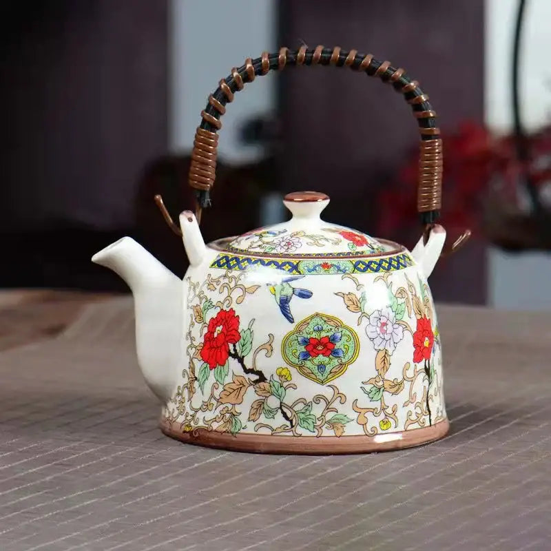 White porcelain teapot with intricate floral and bird designs and woven bamboo handle for dining room decorbites blue set