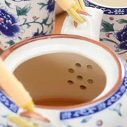 White porcelain tea strainer with blue floral patterns and brown rim for decorbites blue and white porcelain teapot set